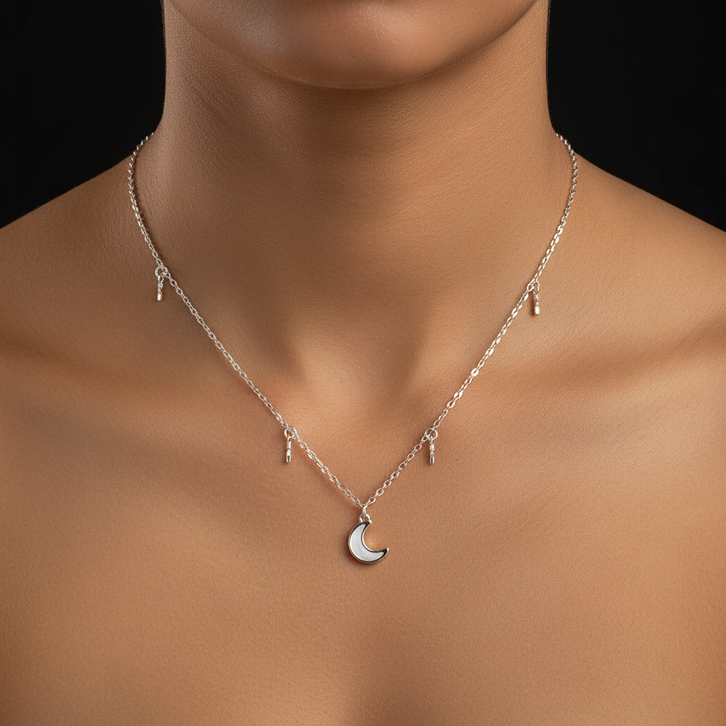 Silver necklace with a moon pendant on a black background